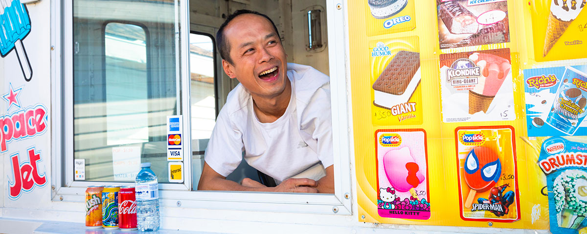 Smiling man leaning out of the window in an ice cream truck