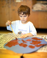 School age boy painting image