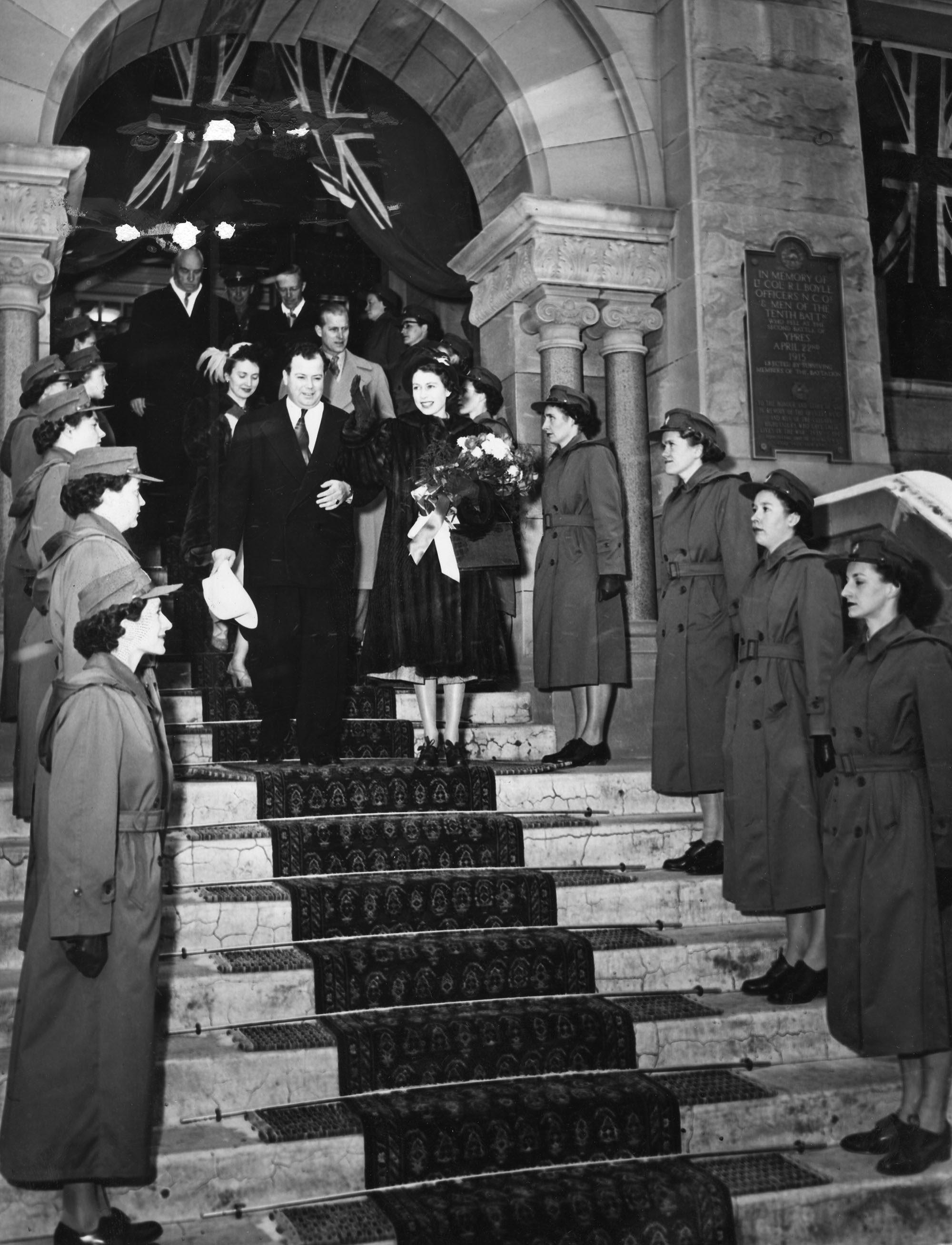 Princess Elizabeth (now Queen Elizabeth) is escorted down the steps of City Hall