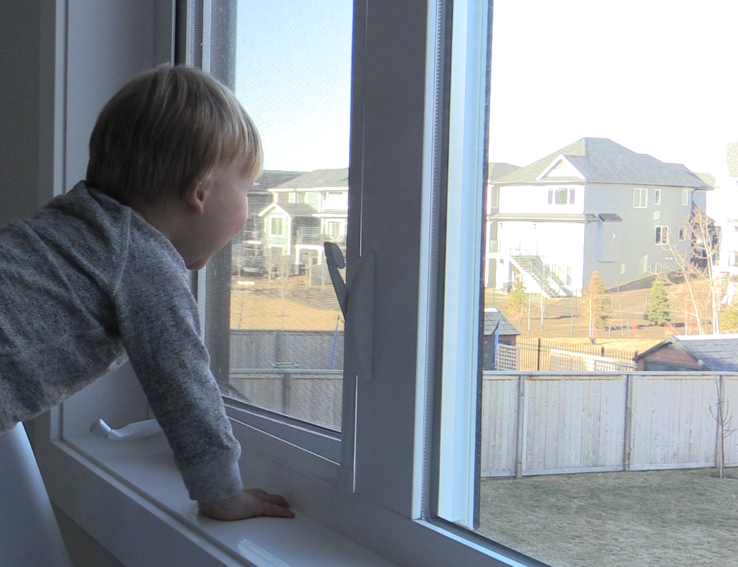 image of child looking out window.