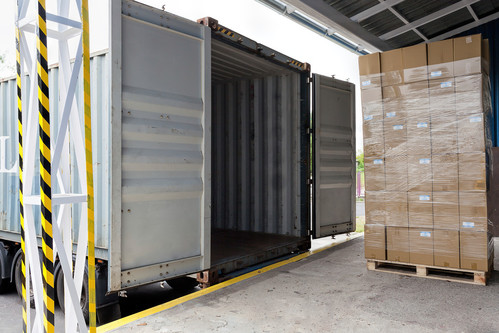 image of a loading dock, with boxes and a semi-truck