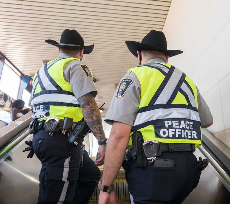 Transit peace officers on a CTrain station escalator