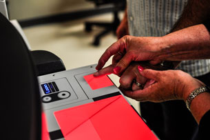 Taking a digital scan of one's fingerprints.