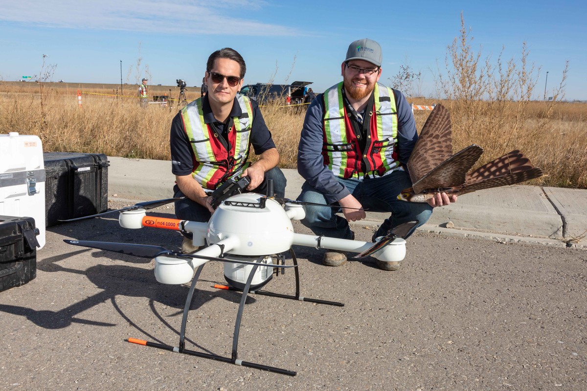 Crew posing with several drones