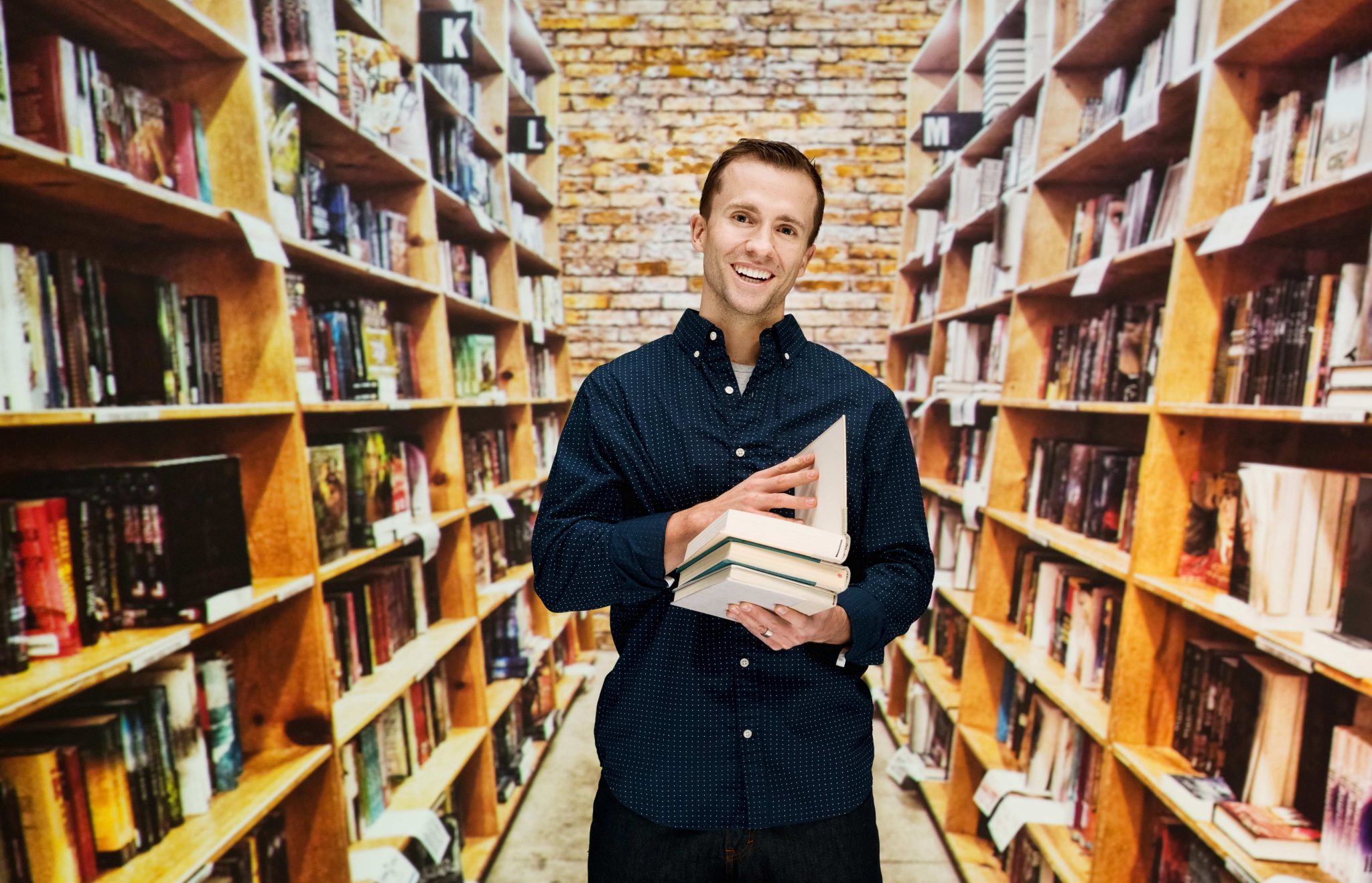 Man in a bookshop holding books