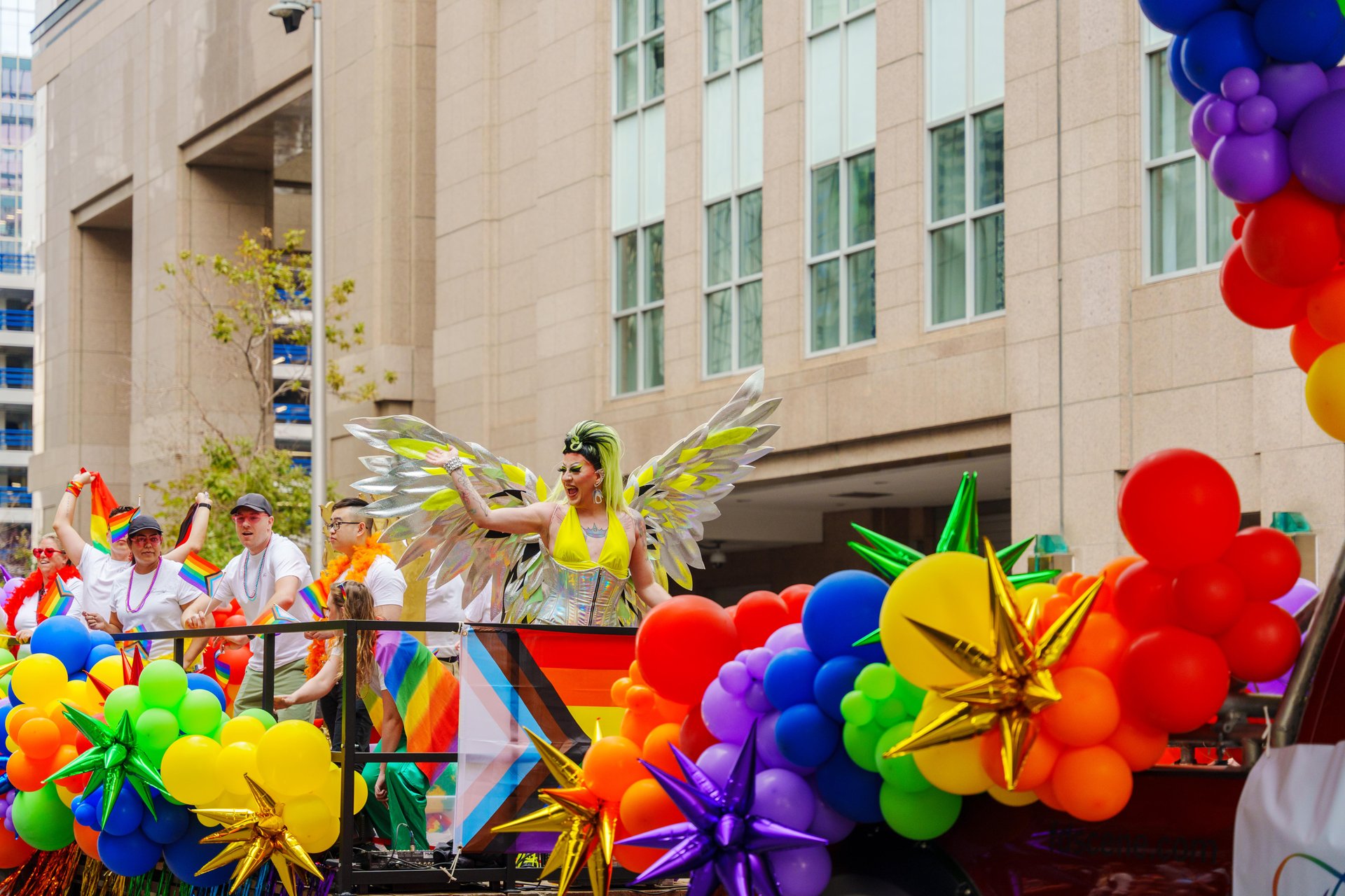 A drag queen in angel wings on a float at the Calgary Pride Parade