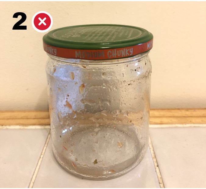 Salsa jar with food bits inside.